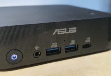 ASUS ExpertCenter PN54-S1, la recensione: mini PC professionale che si configura su misura Front view of an ASUS mini PC: power button with blue ring, two USB-A 3.0 ports, a headphone jack, and a USB-C port on the front panel, black textured case.