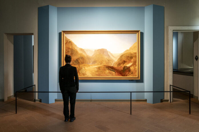 Mostra Turner Como allestimento con pareti cerulee plissettate e illuminazione museale